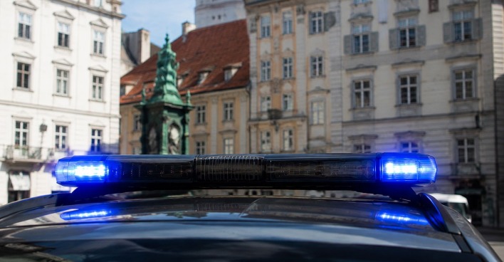 Ein Polizeiauto mit Blaulicht steht vor einem Wohnhaus in Graz