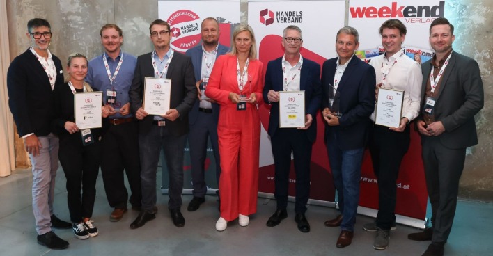 Zehn Personen vor Werbebannern bei der Preisverleihung zum Händler des Jahres 2026