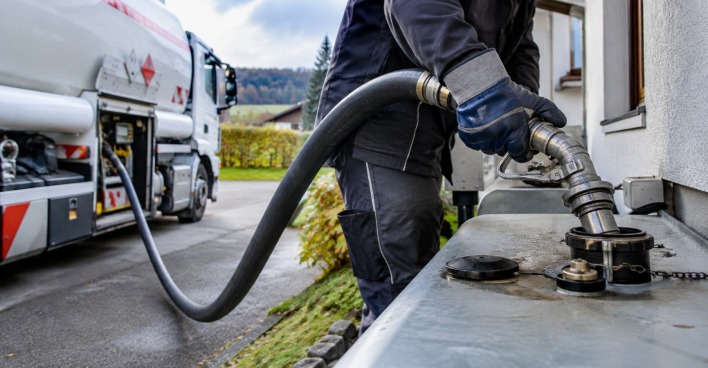 Lieferant füllt Heizöl aus einem Tankwagen in den Heizöltank eines Wohnhauses, Themenbild für die gestiegenen Preise bei Heizöl