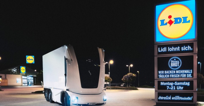 Ein autonomer Lkw von Einride steht auf einem Parkplatz vor einer Lidl-Filiale