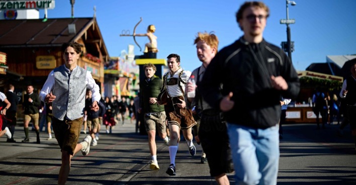 Menschen rennen auf das Oktoberfest.