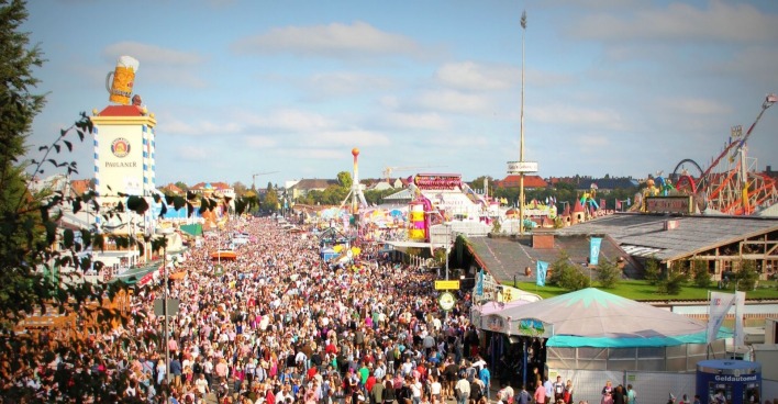 Volle Theresienwiese beim Oktoberfest in München mit zahlreichen Besuchern, Festzelten und Fahrgeschäften.