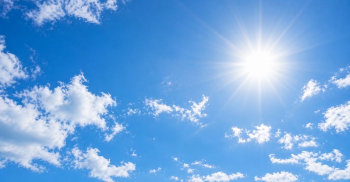 Blauer Himmel mit strahlender Sonne beim spätsommerlichen Wetter in Österreich.