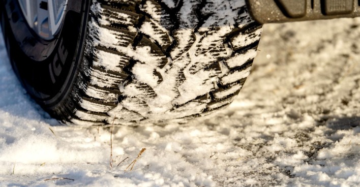 Profiltiefe eines Winterreifens auf einer beschneiten Straße