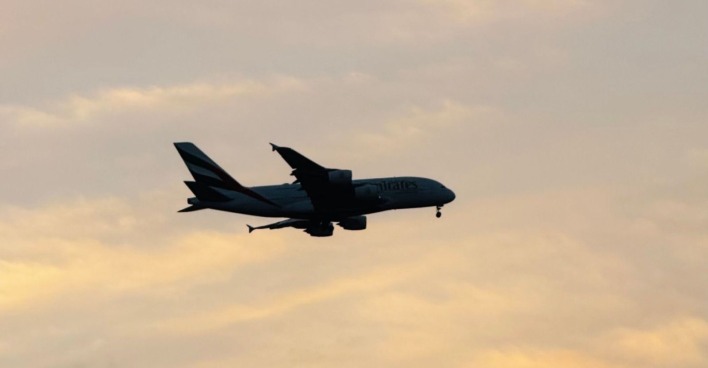 Flugzeug im Landeanflug bei Sonnenuntergang als Symbolbild für Reisen und Online-Buchungen über Booking.com.