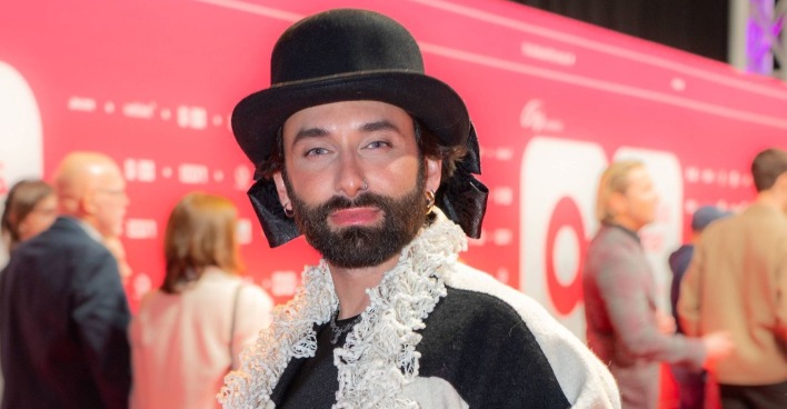 Conchita Wurst mit schwarzem Hut und Bart bei einem öffentlichen Auftritt