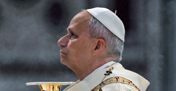 Papst Leo XIV. im weißen Papstgewand und mit weißer Kappe im Seitenprofil während einer kirchlichen Zeremonie.