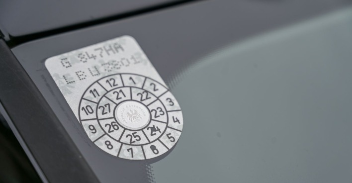 Das sogenannte Pickerl, die Prüfplakette, in einer Fensterscheibe eines österreichischen Pkw