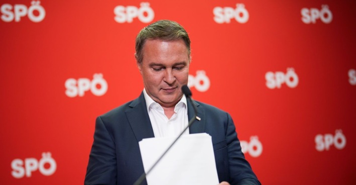 Andreas Babler vor einer roten SPÖ-Wand bei einer Pressekonferenz zum angekündigten Rücktritt