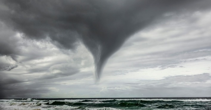 Gewitterwolken und eine Wasserhose über dem Meer