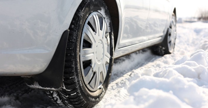 Auto mit Winterreifen auf einer beschneiten Straße