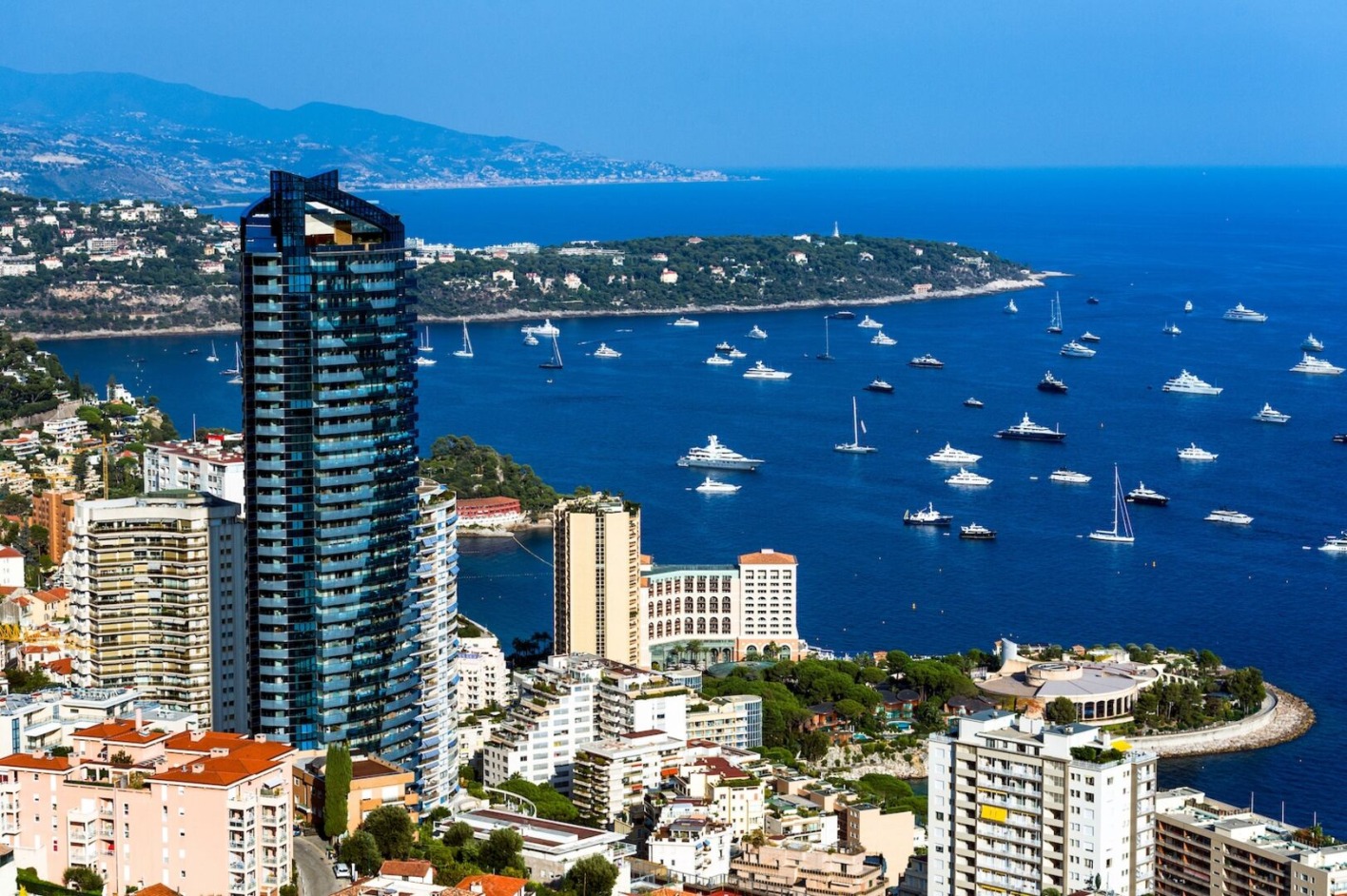 Hochhaus in Monaco, davor Meer und Häuser