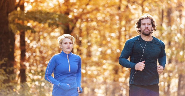 Paar joggt durch herbstlichen Wald