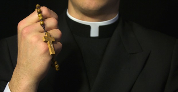 Priester mit Rosenkranz
