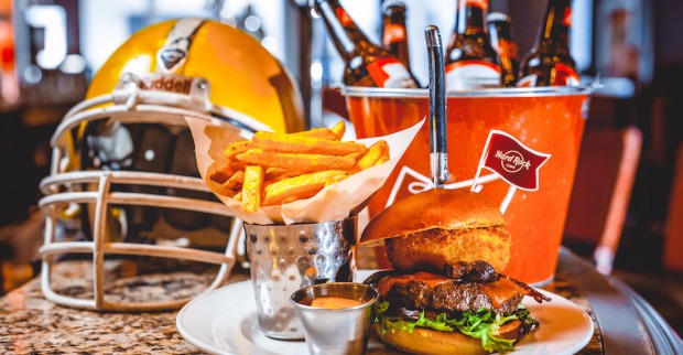 Ein Football-Helm, ein Burger mit Pommes und ein Kühler mit Bierflaschen