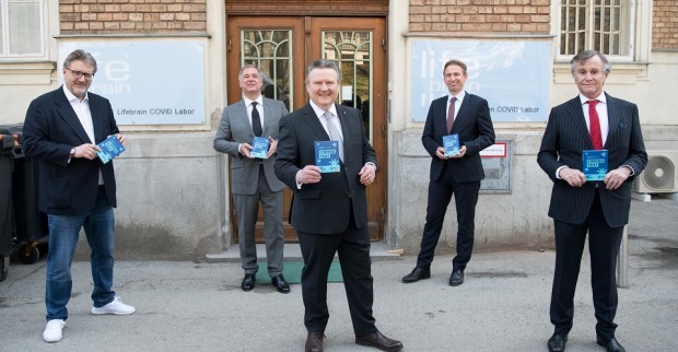 Fünf Männer im Anzug halten eine Broschüre