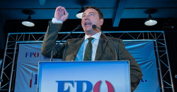 Landeshauptmannstellvertreter Michael Haimbuchner hält auf einer Bühne mit FPÖ Podium eine Rede.