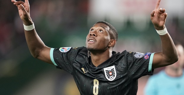 David Alaba im schwarzen Nationaldress blickt nach oben und jubelt mit beiden Händen in der Luft