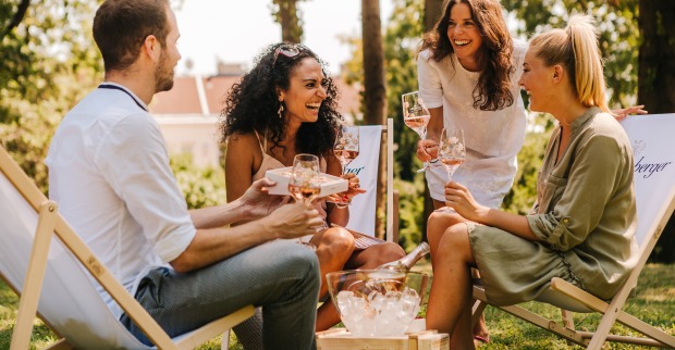 Freundesrunde trinkt im Garten Sekt