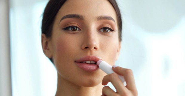 Junge hübsche Frau zieht sich Lippen nach I Puhhha/istockpictures.com