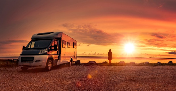 Parkendes Wohnmobill am Seeufer bei Sonnenuntergang | Credit: iStock.com/by-studio