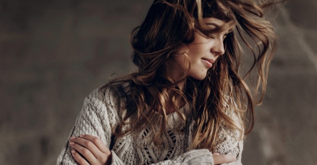 Coole, junge Frau im Wollpullover schüttelt ihr langes Haar | Credit: iStock.com/Bogdan Kurylo