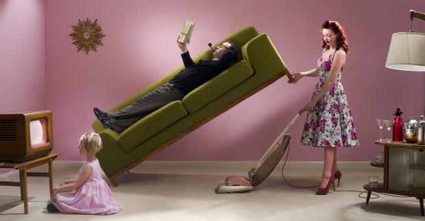 Frau hebt Sofa auf, auf dem der Mann liegt und liest