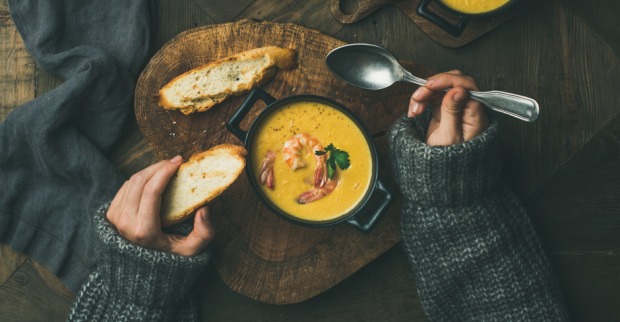 Frau isst Karottensuppe mit Gebäck | Credit: iStock.com/Foxys_forest_manufacture