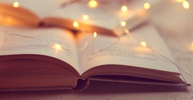 Aufgeschlagenes Buch mit Weihnachtsbeleuchtung | Credit: iStock.com/yul38885