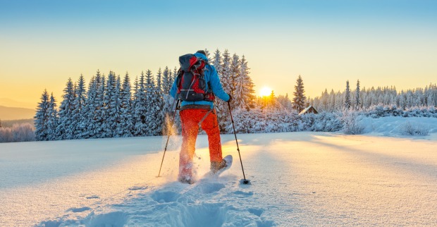 Mann wandert mit Schneeschuhen im Pulverschnee