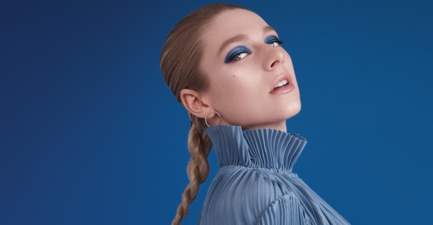 Junge Frau mit blauer Stehkragenbluse und auffälligem blauen Lidschatten