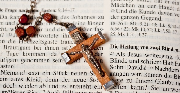 Rosenkranz liegt auf einer aufgeschlagenen Bibel | Credit: iStock.com/LandFoto