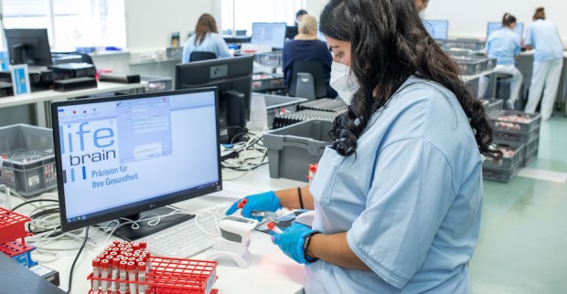Frau arbeitet in einem Covid-Testlabor | Credit: Lifebrain/Christian Husar