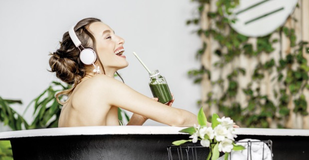 Eine junge Frau die in der Badewanne singt