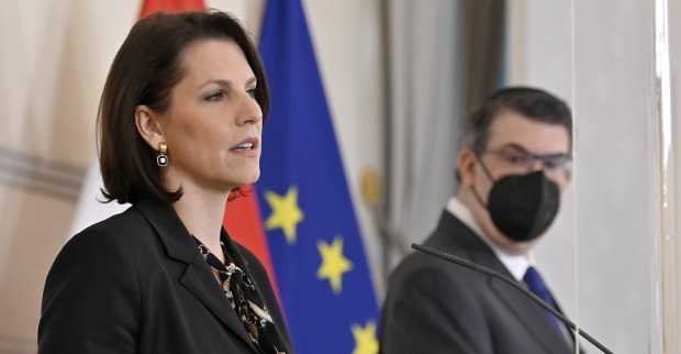 Europaministerin Karonline Edstadler bei einer Pressekonferenz vor den Flaggen Österreichs und der EU