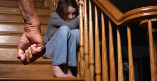 Ein Mädchen sitzt verängstigt auf der Treppe