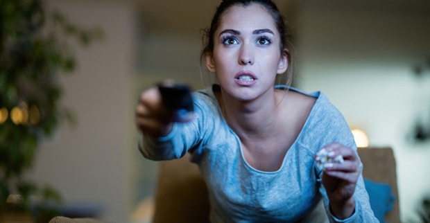 Junge Frau in Hochspannung vor Beginn der Lieblingsserie | Credit: iStock.com/Drazen Zigic