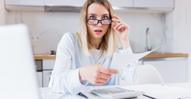 Frau in weißer Bluse mit Brille schaut schockiert | Credit: iStock.com/Liubomyr Vorona
