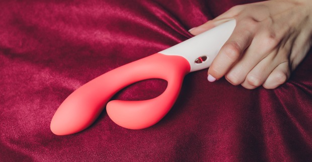 Frau hält Vibrator in der Hand