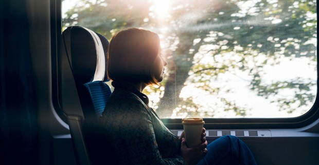 Frau genießt die Aussicht im fahrenden Zug | Credit: iStock.com/Svetlana Ivanova