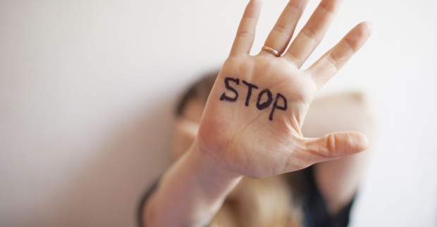 Frau zeigt ihre Hand, auf der "Stop" steht