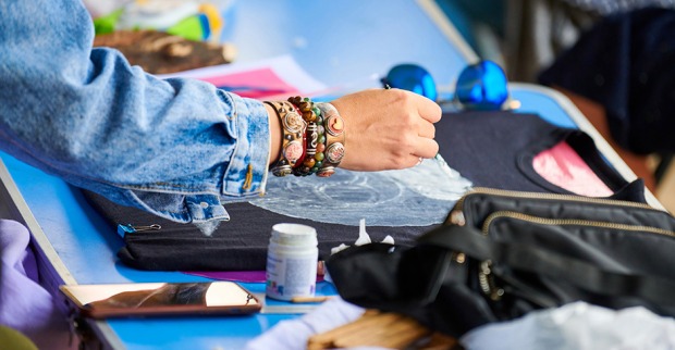 Junge Frau gestaltet ihr T-Shirt um | Credit: iStock.com/TRAVELARIUM
