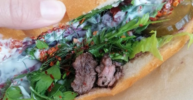 Großaufnahme des Döner-Sandwiches aus der Gumpendorferstraße: Fleisch, Koriander, Zwiebel, Sauce, Gurke, Chili und Rotkraut