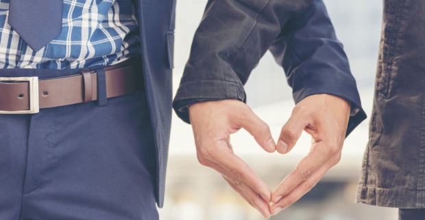 Männer berühren sich in Herzform an den Fingerspitzen| Credit: iStock.com/howtogoto