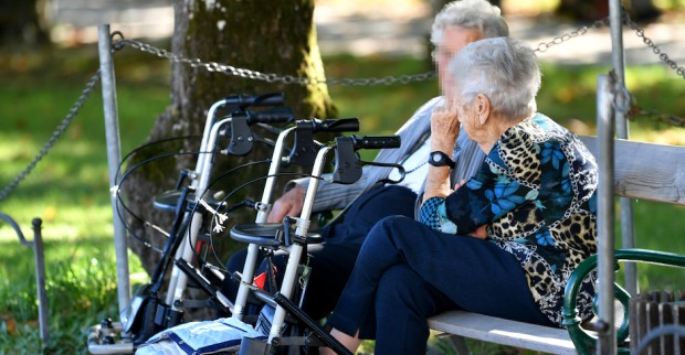 Ältere Menschen auf einer Parkbank im Sommer