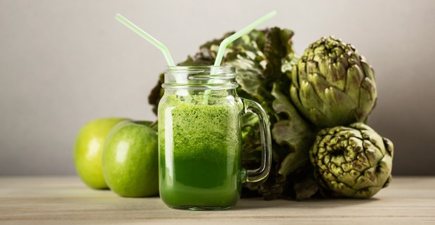 Artischocken und Äpfel arrangiert um einen grünen Smoothie | Credit: iStock.com/alexsalcedo