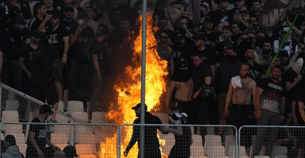 Hooligans, die auf einer Fußballtribüne ein Feuer entfacht haben.