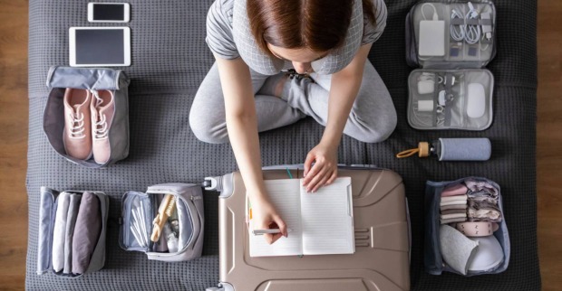Junge Frau beim Kofferpacken | Credit: iStock.com/Kostikova