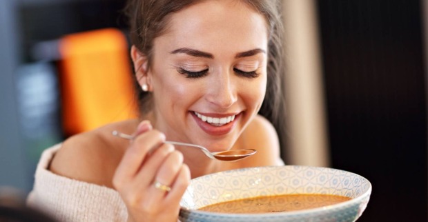 Junge Frau beim Genuss einer Kürbissuppe | Credit: iStock.com/macniak