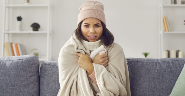 Frierende Frau auf der Couch | Credit: iStock.com/Lacheev